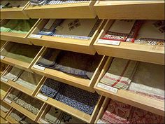 the shelves are filled with many different fabrics