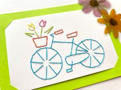 a close up of a piece of paper with flowers and a bike drawn on it