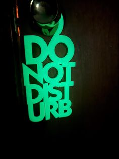 a door handle that has the words do not disturb on it in neon green letters