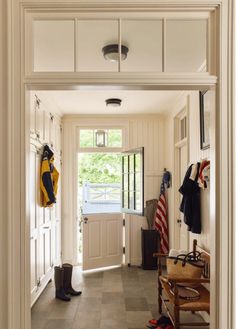 an entry way with white walls and tile flooring