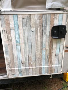 an old wooden trailer door is painted white and blue with black latches on it