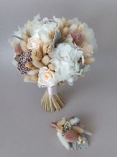 a bridal bouquet with white flowers and seashells