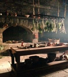 a table with pots and pans on it sitting in front of an open fire place