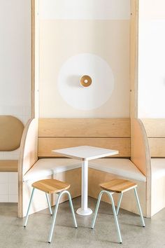 Two backless low stools at a table with a graphic mural painted on the wall behind it. Cafe Seating Design, Mid Century Cafe, Modern Cafe Design, Chair Cafe Design, Cafe Furniture Design, Shop Architecture, Cafe Chair, Cafe Seating, Coffee Shop Interior Design