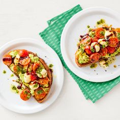 two white plates topped with slices of toast covered in veggies and toppings