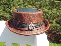 "It's Spring and Time to treat yourself to a New Custom Made Hat!  These hat's I hand make, one at a time in my little shop in a smoke free/pet free home.  The body of the hat is a 5 oz oil tanned leather tanned in the USA, it is also available in Black.  The green trim is actually from an Icelandic deer.  I get beautiful color's from them, almost any color can be had, so if you are interested in a different color let me know.   There is a millinery wire in the brim, to allow the hat's brim to be shaped how you choose, and it's a 19 gauge wire so it is pretty strong.  The hat can be packed flat and easily pops back up into shape. which is a huge plus! This sale is for a Handmade leather hat with a Hatband.  I can add a buckle, which add's a little color (Typically brass for brown's and chr Custom Made Hats, Leather Hat, Tanning Oil, Leather Crafts, Leather Hats, Handmade Hat, Leather Projects, Hat Band, Female Travel