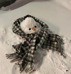 a snowman wearing a scarf and hat in the snow