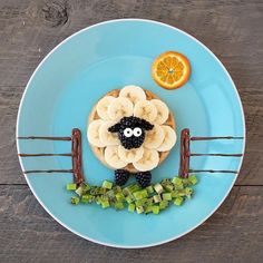 a blue plate topped with bananas, kiwis and orange slices on top of it