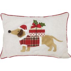 a dog wearing a santa hat and scarf with presents on it's back, sitting in front of a white pillow