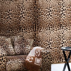 a leopard print couch and table in front of a wall with an animal pattern on it