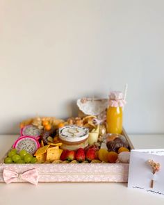 an assortment of cheeses and fruit in a tray with a note on the side