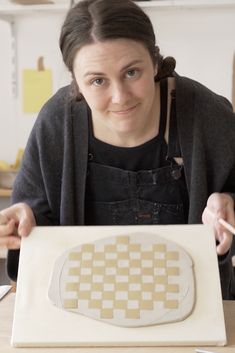 a woman sitting at a table with an art project