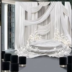 an image of a stage set up for a wedding ceremony with white flowers and black candles