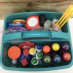 a blue plastic container filled with lots of different types of toy balls and other items