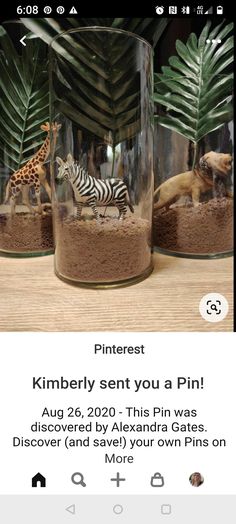 two glass jars filled with fake animals on top of a wooden table next to each other