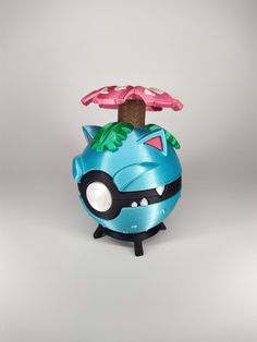 a blue toy with a pink tree on it's head and two small leaves sticking out of the top