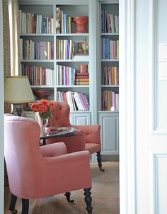 a living room filled with lots of books and furniture