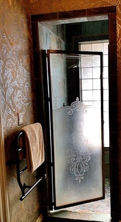 a bathroom with a glass shower door and towel rack