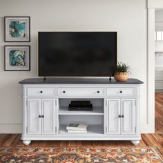 a flat screen tv sitting on top of a white entertainment center