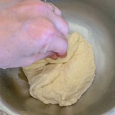 someone is kneading dough into a bowl