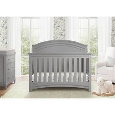 a baby crib in a room with white furniture