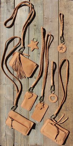 several leather items are laid out on a wooden surface, including two purses and one wallet