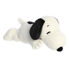 a white stuffed dog laying on its side with black eyes and nose, it's head tilted to the ground