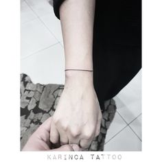 a person with a small tattoo on their wrist holding the hand of another person's arm