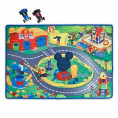 a mickey mouse play mat with cars and buildings on it, including a train track