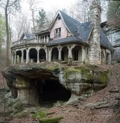 an old house built into the side of a cliff with a cave in front of it