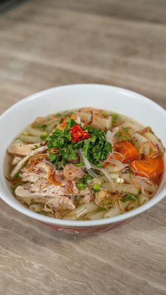 a white bowl filled with soup on top of a wooden table