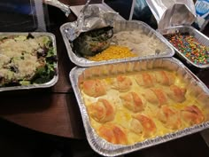 several trays of food sitting on top of a table