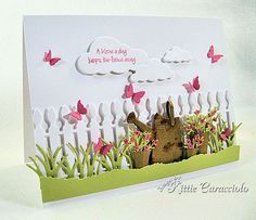 a greeting card with a teddy bear in the grass and butterflies flying above it, on a white background