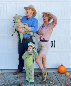 two adults and a child dressed up in costumes, standing next to a garage door