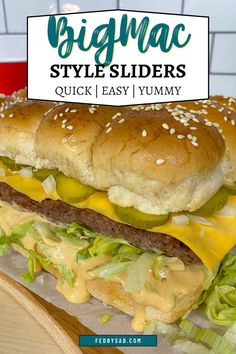 a large cheeseburger with lettuce and pickles is on a tray