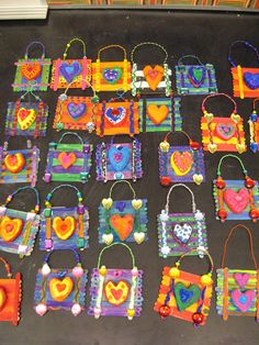 many colorful bags are on the floor with beaded handles and hearts hanging from them