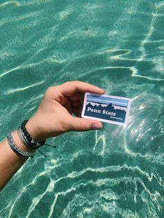 a person holding up a business card in the water