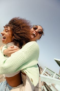 two women hugging each other on the beach