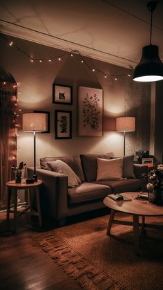 a living room filled with furniture and lights on the wall above it's coffee table