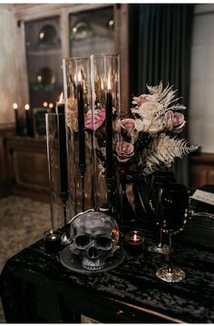 a table with candles, flowers and a skull on it