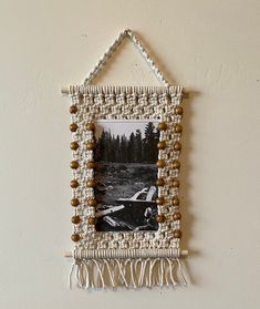 an old photo hanging on the wall with beads and tassels attached to it