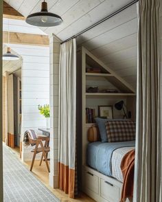 an attic bedroom with white walls and wood flooring, built into the side of a house