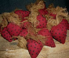 some red and black hearts are sitting on a wooden table with burlocks around them