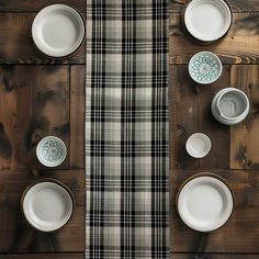 the table is set with white dishes and plaid napkins on it's sides