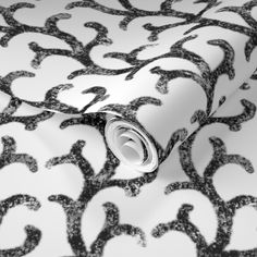 black and white wallpaper with an ornate design on it's surface, in the middle