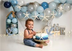 a baby sitting on the floor with a cake