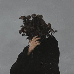 a woman holding flowers in her hands with snow falling on her face and behind her head