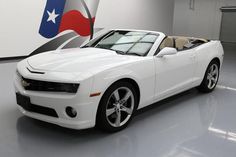 a white sports car is parked in a garage with an american flag painted on the wall