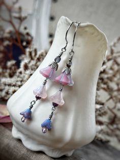 o*. ✿ .*o Fairy Bell Flower Earrings o*. ✿ .*o ✿ About This Pair ✿ --Length: approximately 2.75" long. --Antique silver with pale pink and lavender Czech glass bell flower beads. --Featuring graceful round silver finished stainless steel ear wires. Whimsical Dangle Flower Earrings, Whimsical Silver Flower Earrings, Whimsical Handmade Silver Flower Earrings, Whimsical Silver Flower Earrings With Ear Wire, Whimsical Silver Dangle Flower Earrings, Silver Whimsical Flower Earrings, Whimsical Adjustable Nickel-free Flower Earrings, Whimsical Nickel Free Dangle Flower Earrings, Whimsical Nickel-free Drop Flower Earrings