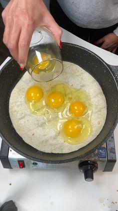 three eggs being cooked in a frying pan on top of an electric burner